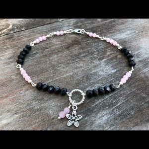 Handmade black and pink anklet with Bali charm